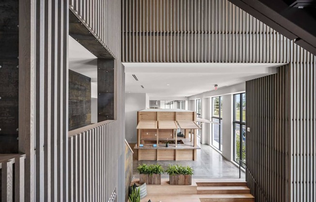 A modern interior with a long hallway and a staircase on the left.