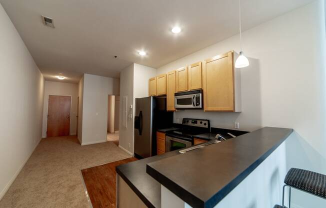 a kitchen with a black counter top and a black stove top oven at 26 West, Managed by Buckingham Urban Living, Indianapolis