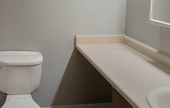 A white toilet sits next to a sink in a small bathroom.