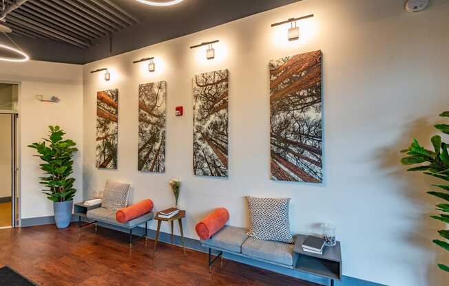 a living room with couches and paintings on the wall