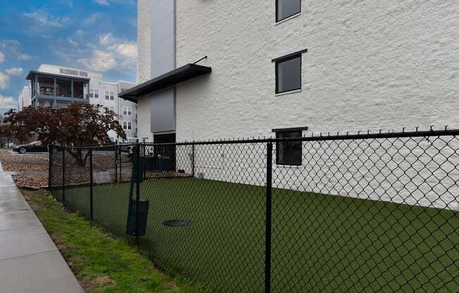 A white building with a black fence in front.