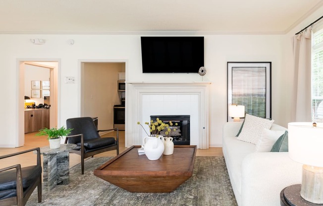 a living room with a white couch and a coffee table and a fireplace