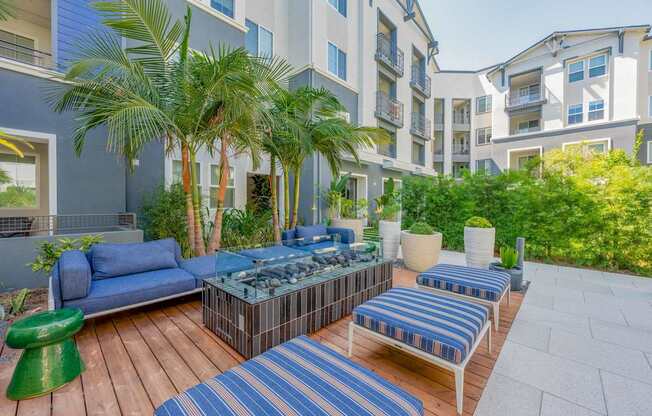 A patio with blue furniture around a fire pit