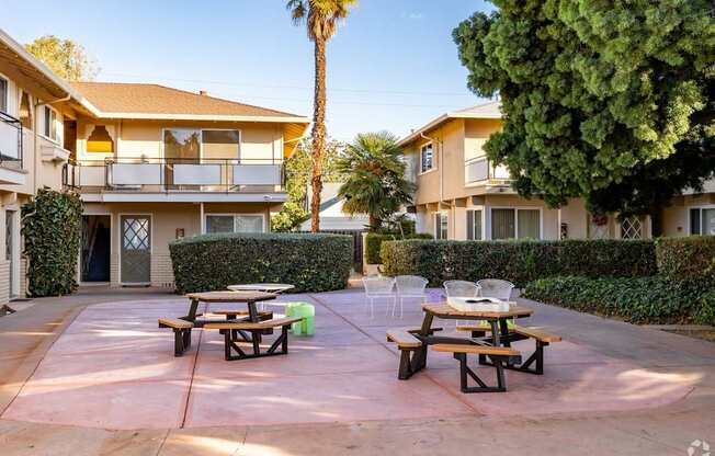 a patio with tables and chairs in a courtyard