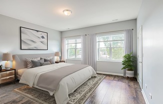 a bedroom with a bed and two windows