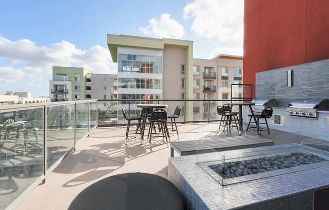 A modern outdoor kitchen area with a grill and seating area.