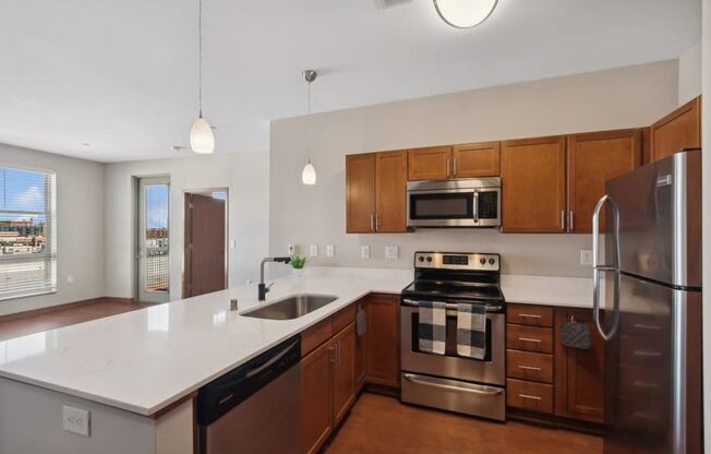 a large kitchen with stainless steel appliances and white counter tops