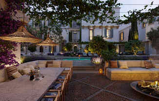 a patio with a table and chairs and a pool