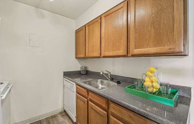 A kitchen with wooden cabinets and a white dishwasher.