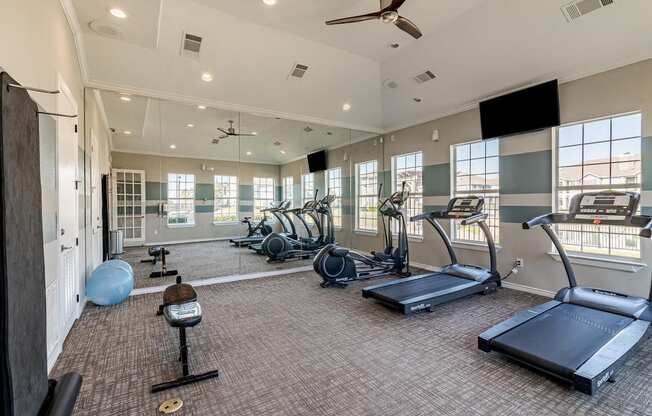 a gym with exercise equipment and windows in a building