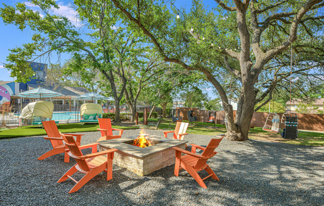 a patio with a fire pit and chairs around it