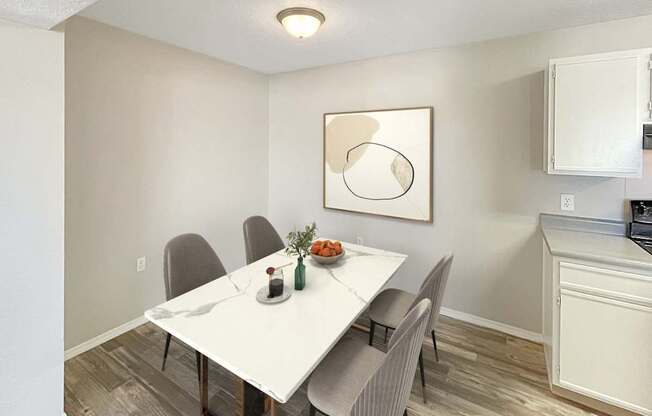 A dining room with a white table and chairs.