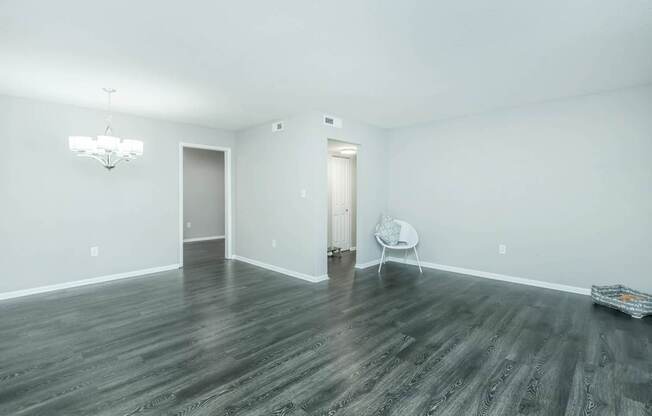 A room with a wooden floor and a white chair.