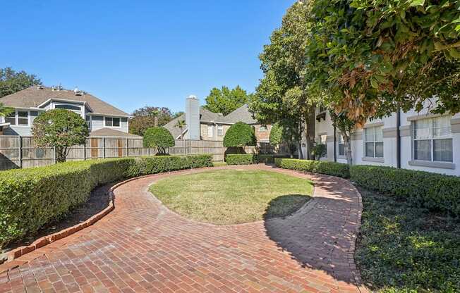 A residential area with a brick pathway and houses on either side.