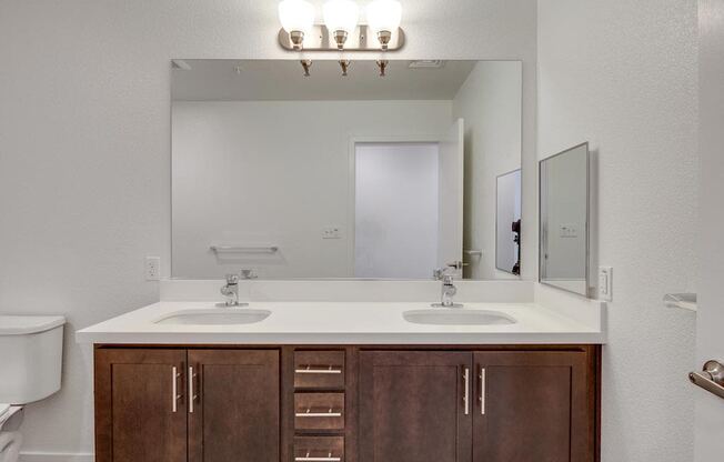 a bathroom with two sinks and a mirror