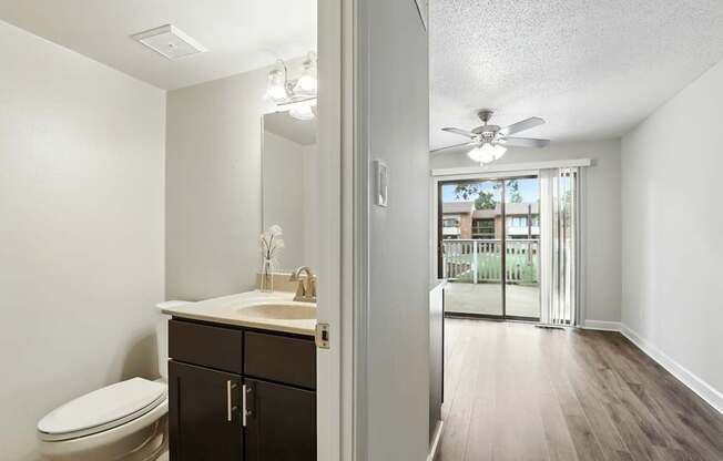 A bathroom with a toilet, sink, and mirror.