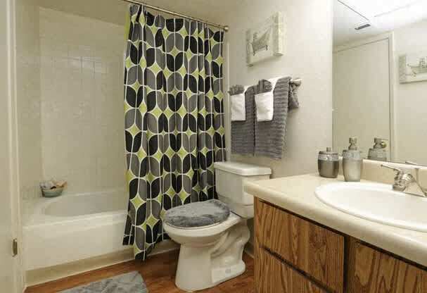 A bathroom with a toilet, sink, and shower curtain.