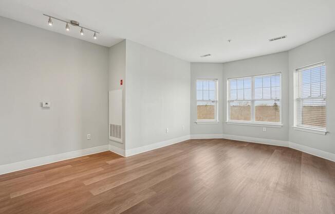 A large empty room with wooden floors and white walls.