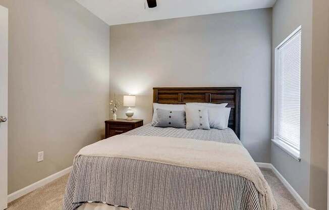 a bedroom with a bed and a window. Circle Pines, MN Lexington Lofts