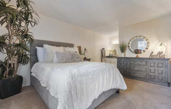 a bedroom with a bed and a dresser and a mirror