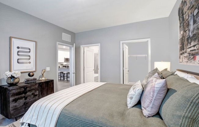 a bedroom with a large bed and a door to a bathroom