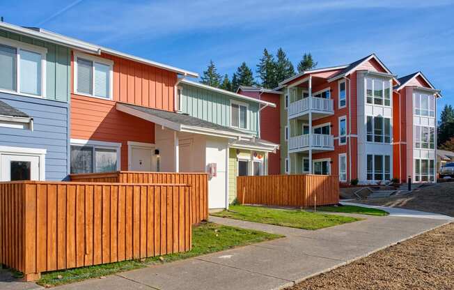 a row of colorful homes in front of a sidewalk at Woodcreek, Poulsbo
