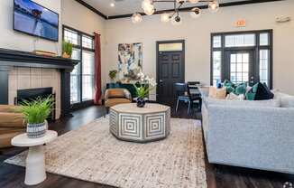 A living room with a fireplace and a grey couch.