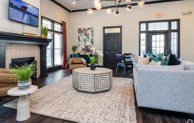 A living room with a fireplace and a grey couch.
