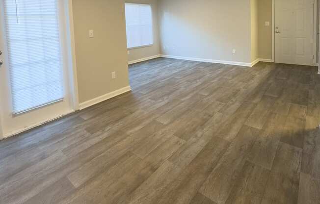 A room with light wood flooring and a ceiling fan.