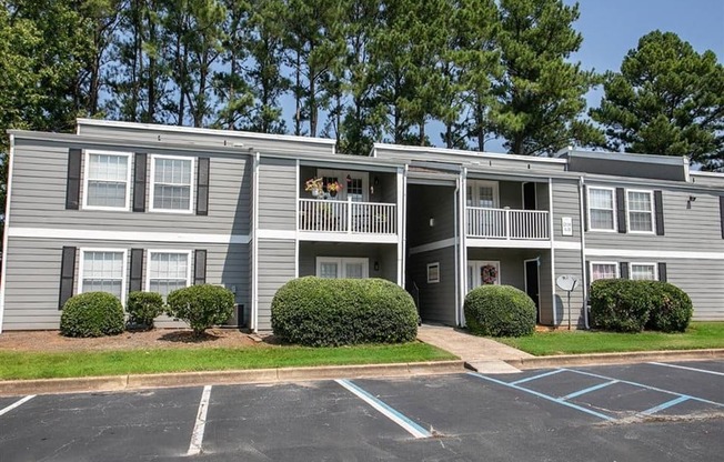 an apartment building with balconies and a parking lot