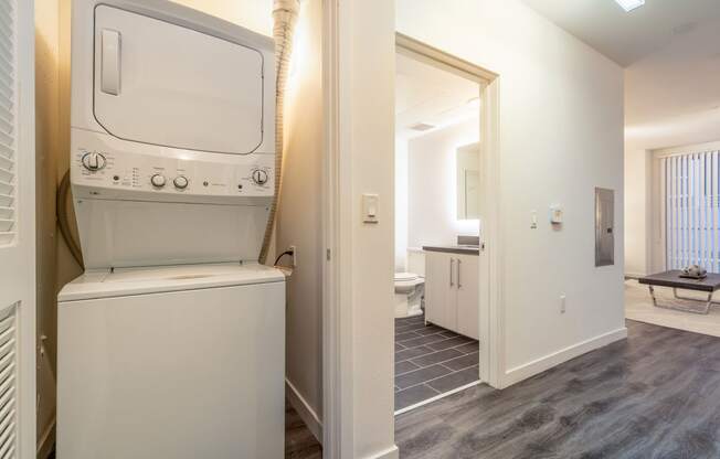 a laundry room with a washer and dryer and a door to a bathroom