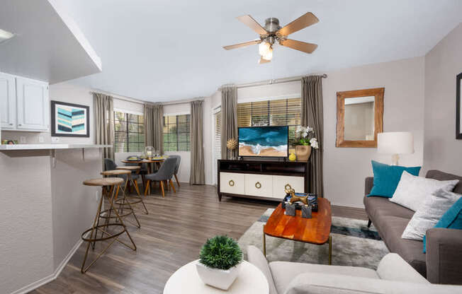 A living room with a white couch, a wooden coffee table, and a ceiling fan.