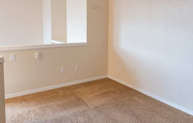 A room with brown carpet and white walls.