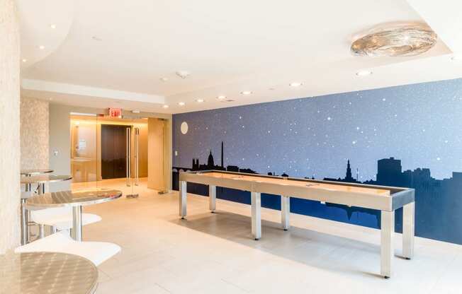 a game room with a pool table and a wall mural of the city skyline