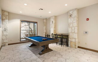 a game room with a pool table and a bar at Lakeline East Apartments, Texas