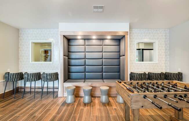 a game room with a foosball table and chairs