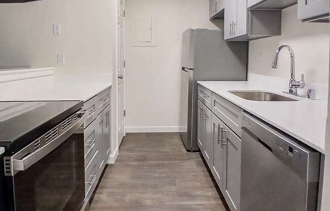 A kitchen with a stainless steel dishwasher and oven.