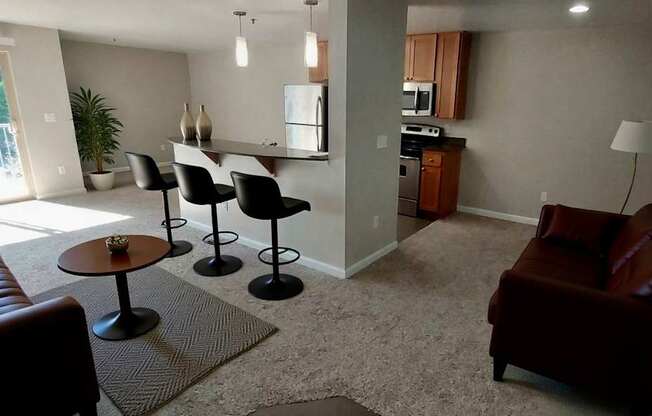 A living room with a brown couch and a table with chairs.