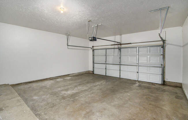 An attached garage with a white wall and a white door at Foxwood and The Hermitage, Portage, MI, 49024
