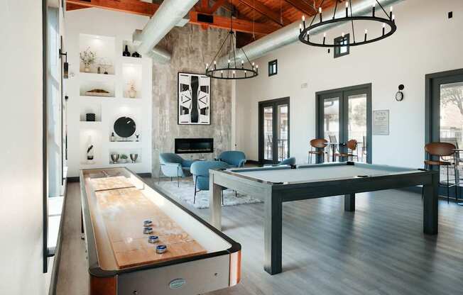 A pool table is in the middle of a room with a couch and a chair.