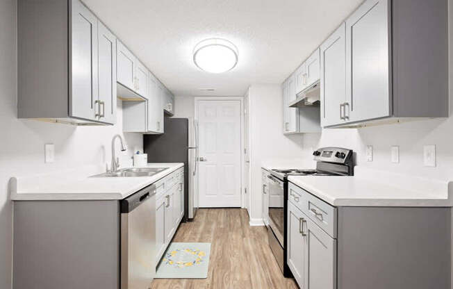 A kitchen with white cabinets and a white counter top.
