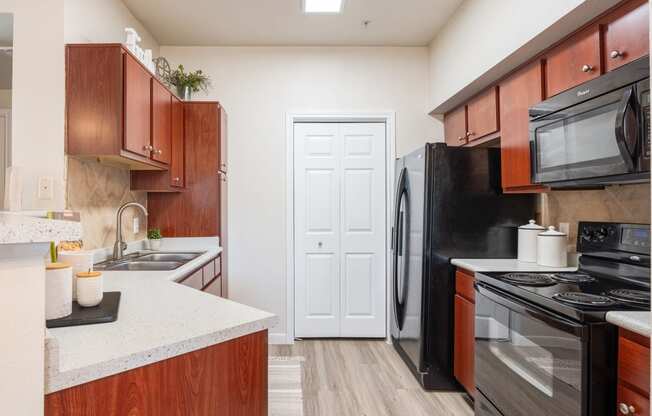 a kitchen with black appliances and wood cabinets