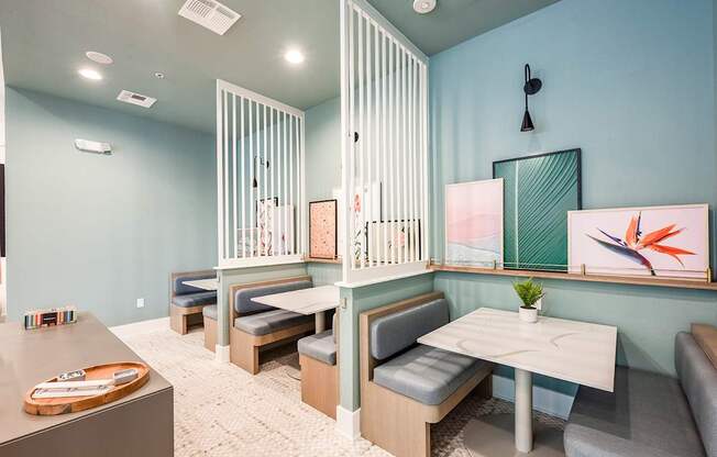 A room with a table and chairs and a painting on the wall.