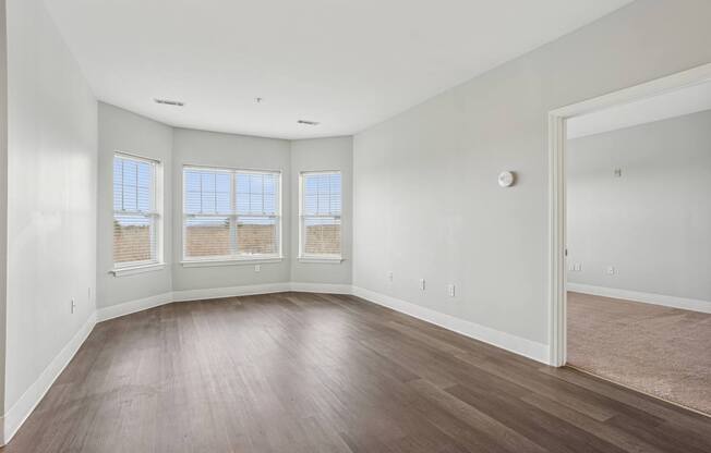 A room with wooden floors and a large window.