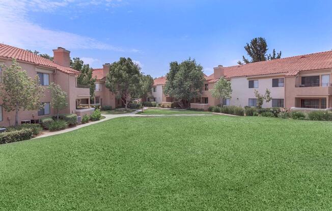 a large brick building with green grass in front of a house