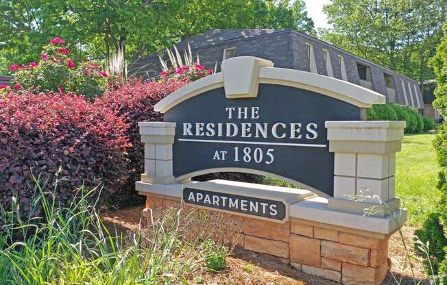 a sign for the residence at 1886 in front of a garden