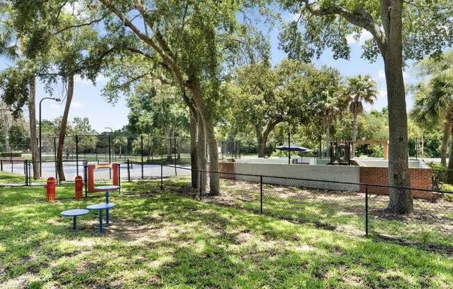 a park with a tennis court and a playground and trees