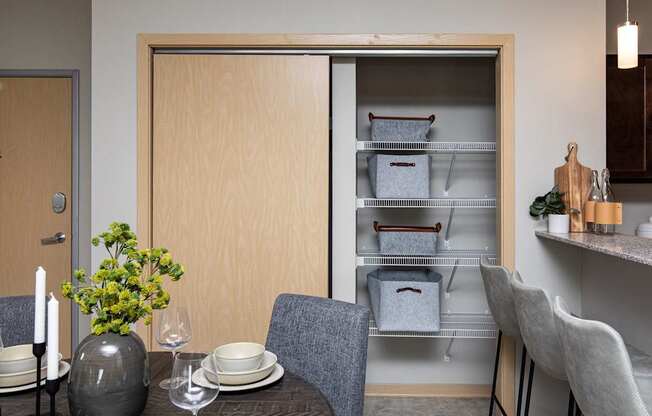 a dining room with a table and chairs and an open refrigerator at Lake Shore Apartments, Ankeny, 50021