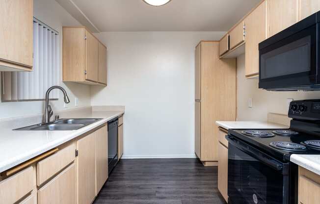 a kitchen with wood cabinets and a black stove top oven