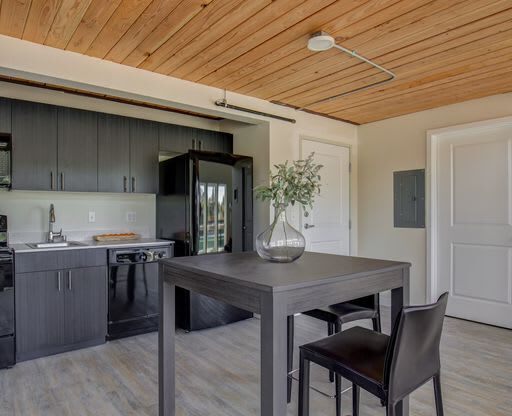 a kitchen and dining room with a wooden ceiling